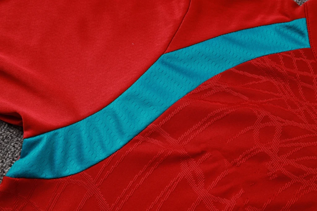 Close-up of breathable textured fabric and teal panel on soccer training top
