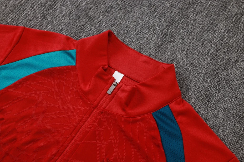 Red soccer training top featuring zip stand collar and textured fabric