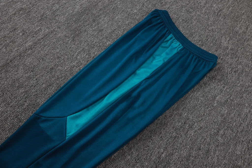 Teal soccer training pants with contrasting textured side panel